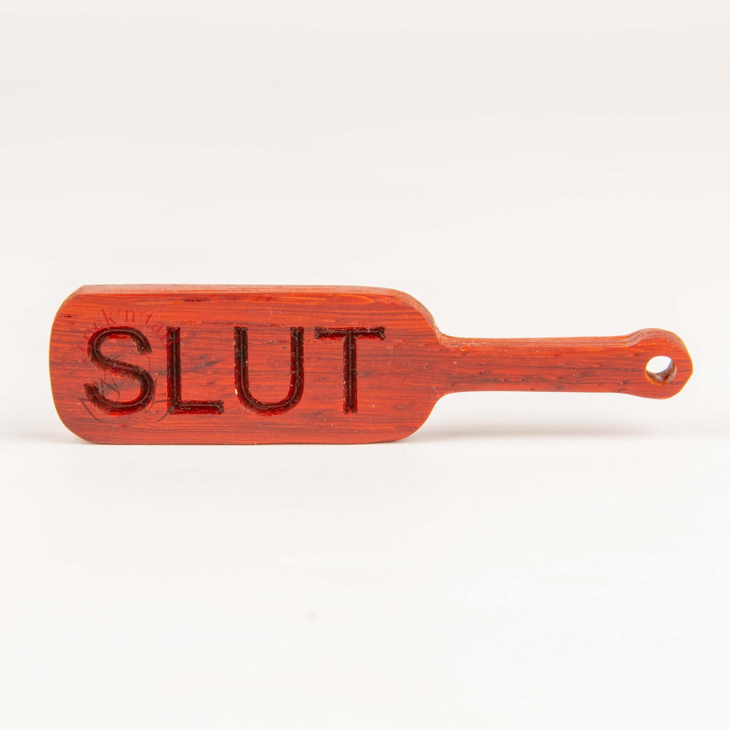 Paddle shaped keychain with the word "SLUT" engraved